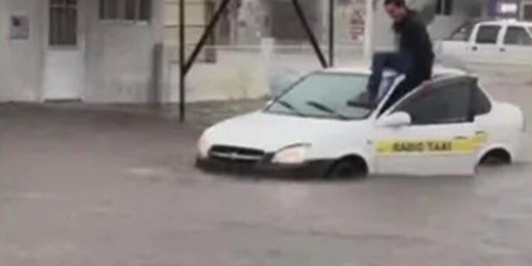 Taxista se abriga em cima de carro para fugir de alagamento em Santana do Livramento